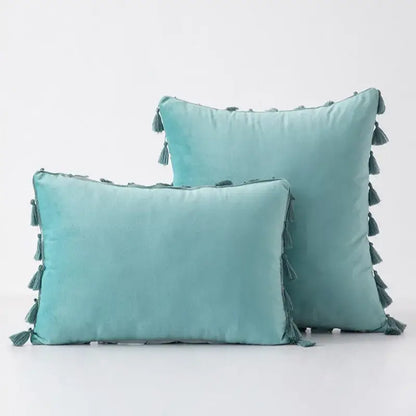 Teal velvet pillow covers with tassel fringe along edges for boho home decor living room accents