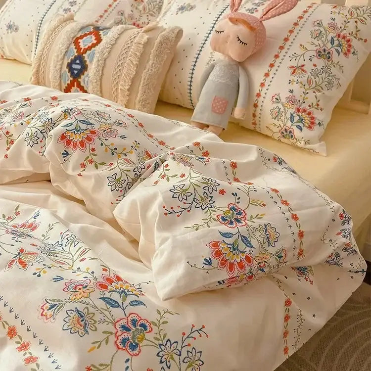 Cream-colored floral bedding set featuring embroidered boho pattern printed blossoms in soft reds, oranges, and blues by decorbites