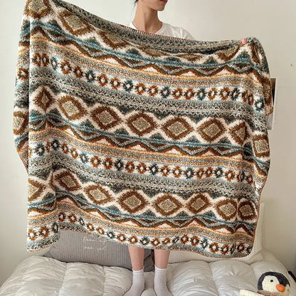A cozy chunky knit boho printed blanket with earthy geometric pattern in brown teal and cream for bedroom use