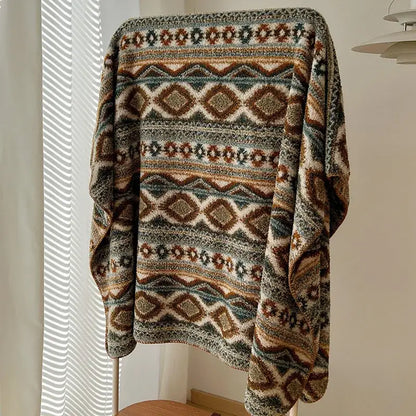 A boho printed chunky knit blanket in earthy brown beige and muted green with a geometric pattern for bedroom use