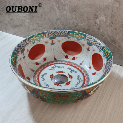 Ouboni boho retro ceramic bathroom sink with intricate red green and gold floral pattern on white background
