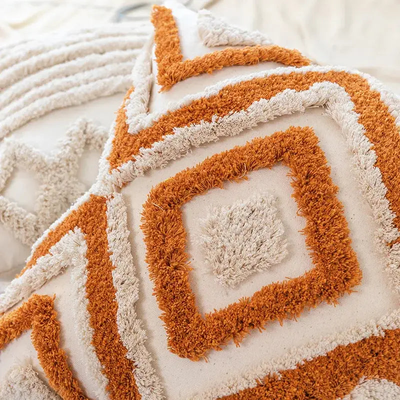 Boho square pillowcase with warm orange geometric pattern, cream tones, and plush fringed yarn accents by decorbites boho