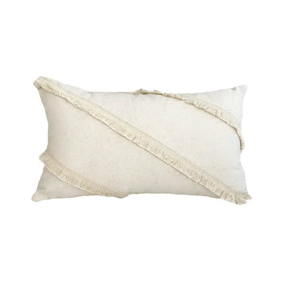 Cream-colored boho style cushion cover in natural linen with diagonal fringed stripes and tassels for living room decor