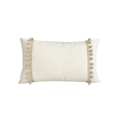 Cream-colored boho style linen cushion cover with soft pom-poms for stylish living room decor by decorbites boho style