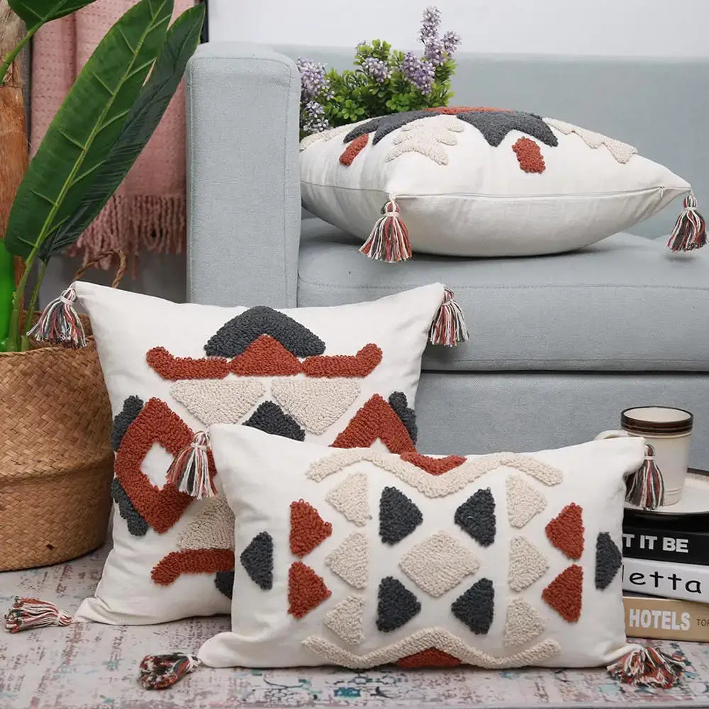 Cream-colored boho style embroidered pillow cover with rust geometric embroidery and multicolored tassels decorbites decorbites