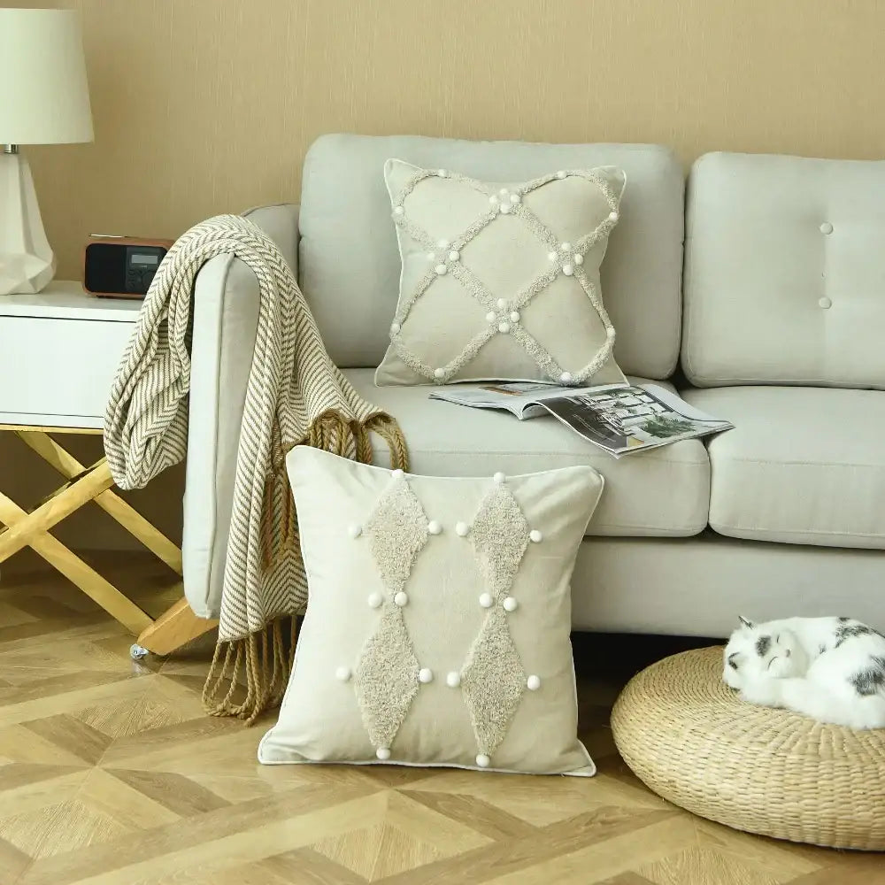 Beige cushion cover with textured diamond appliqués and white pom pom accents for decorbites boho style ivory decor