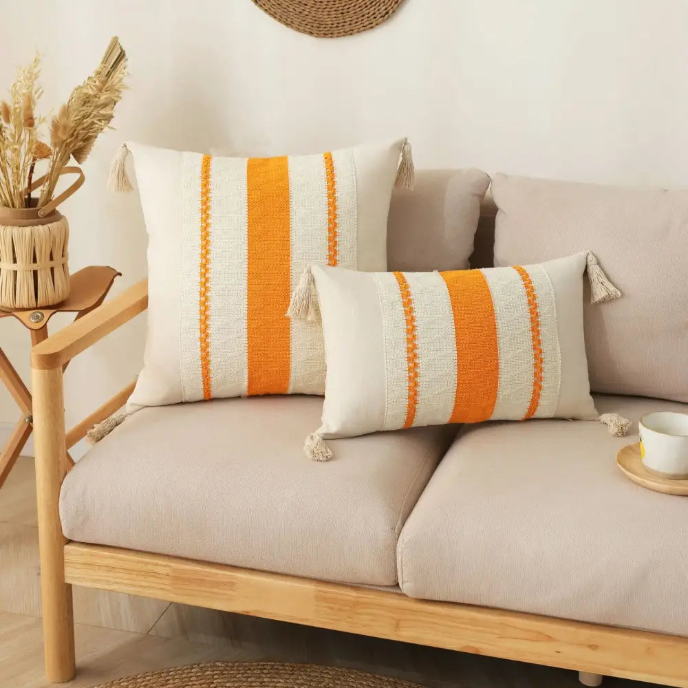 Cream-colored boho tassel cushion cover with bold orange stripes and tassels for beige and gray living room decorbites