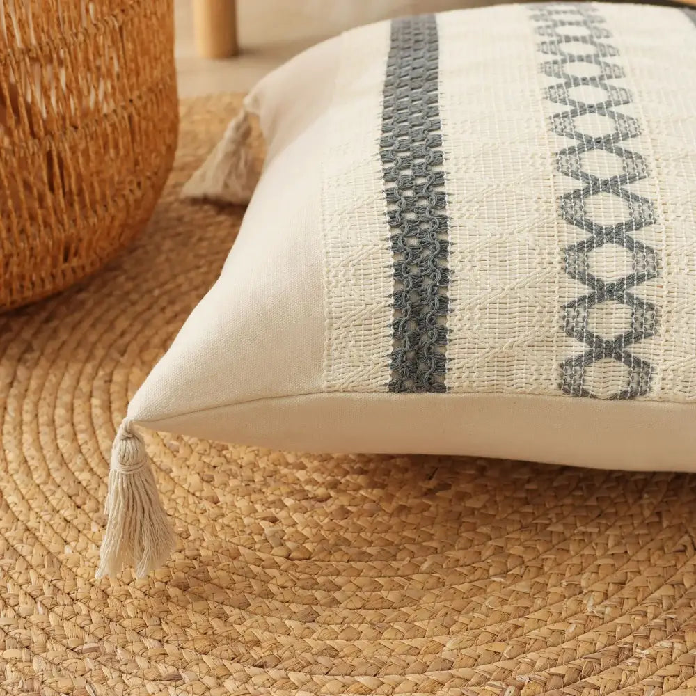 Cream-colored boho tassel cushion with textured gray embroidered stripe and tassel in decorbites boho tassel cushion cover