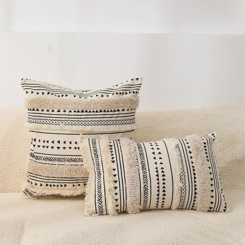 Cream-colored boho tufted fringed black and white throw pillows with geometric patterns for living room decorbites decor