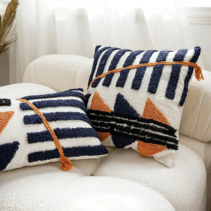 Two boho tufted pillow covers in navy and burnt orange with chunky yarn tufts and braided tassels for living room decorbites decor