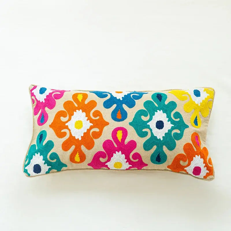 Boho vintage embroidered alpaca lumbar pillow with vibrant orange pink teal and yellow floral motifs on beige decorbites fabric