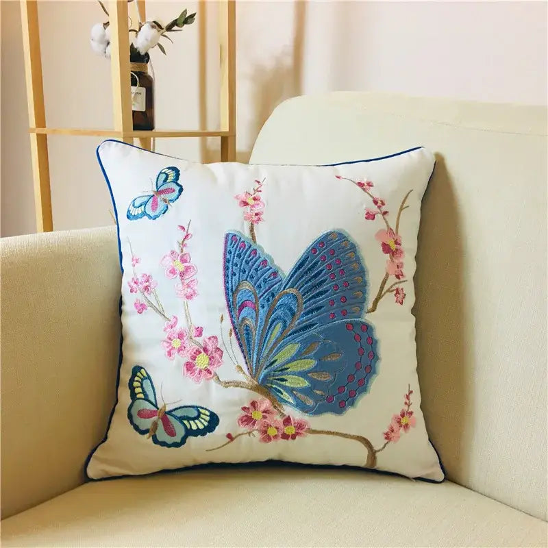 White alpaca lumbar pillow case with intricate blue and pink embroidered butterflies and navy border boho vintage embroidered decorbites