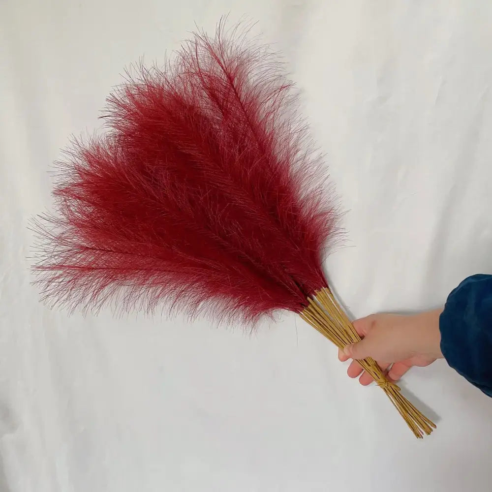 A vibrant red fluffy pampas grass bouquet with natural stems for boho white and beige living room decor by decorbites
