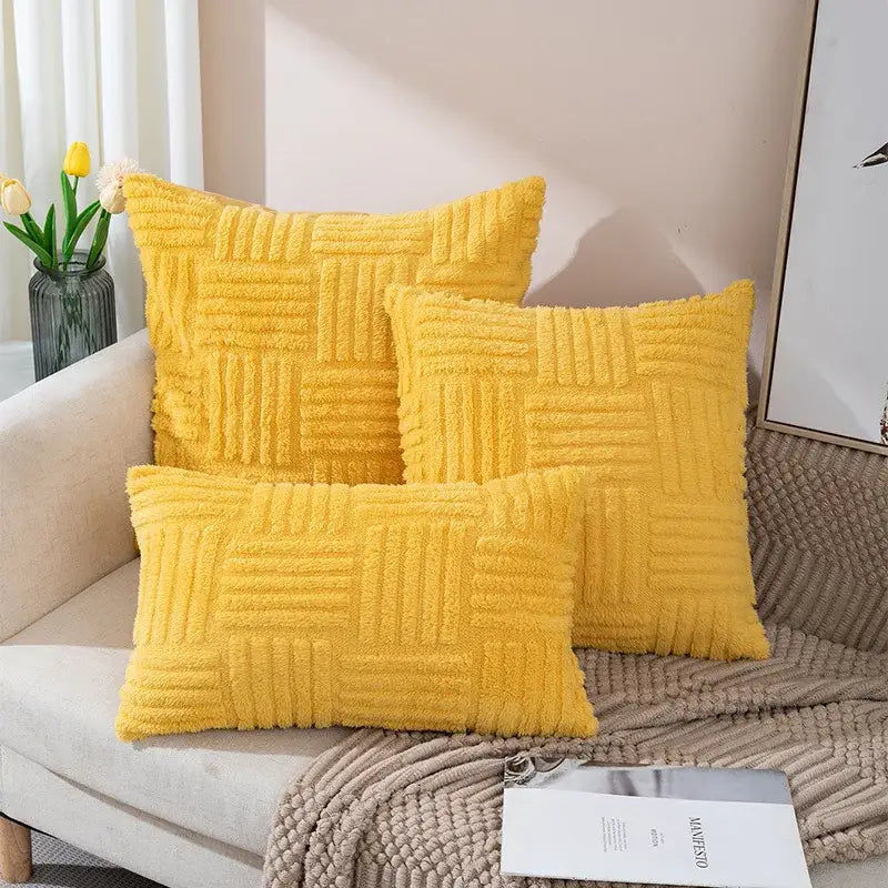 Three vibrant yellow plush throw pillow covers with a textured woven pattern arranged on a cozy sofa for living room decor