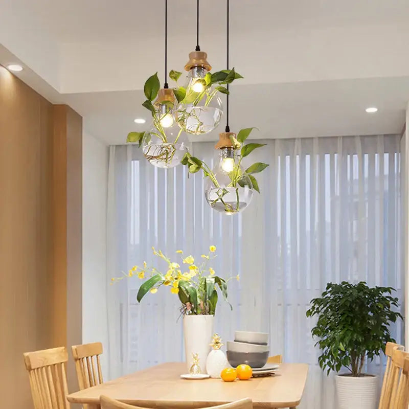 Clear glass pendant light with wooden accents and live green vines from decorbites botanical glass bottle collection