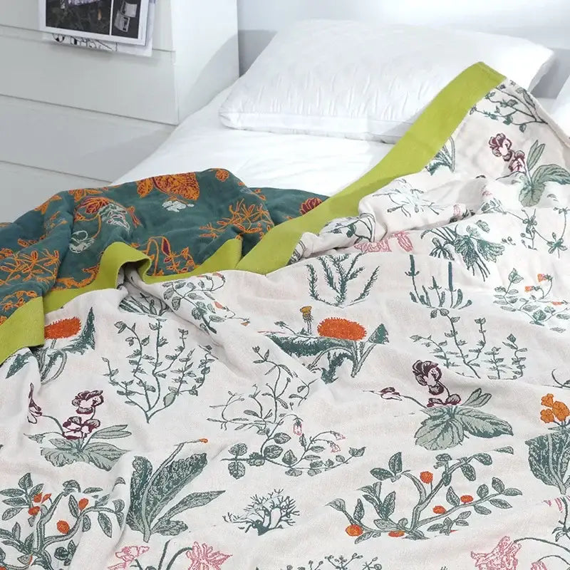 A decorbites cotton leisure two-toned quilt with botanical print in cream and teal and lime-green border cotton leisure blanket