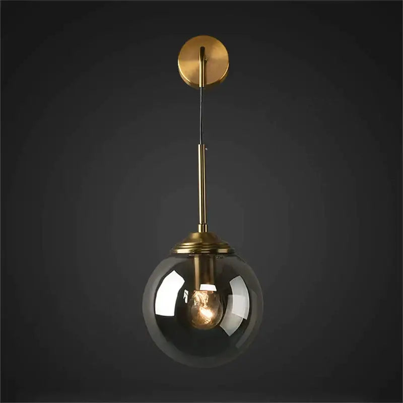A brass amber glass ball wall light with a sleek brass finish and smoked glass globe for bedroom and living room decorbites glass ball