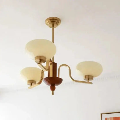 Vintage-style brass and wood glass pendant chandelier with cream glass shades for dining room decorbites cream glass