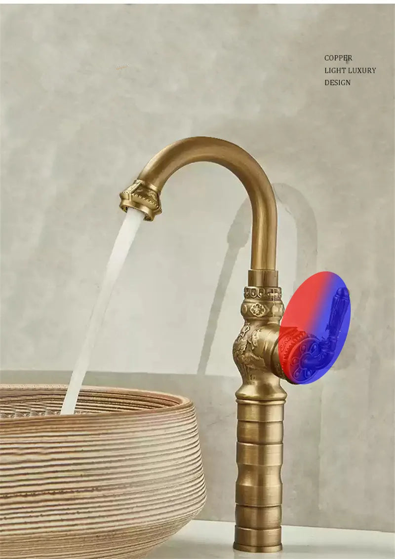 Brass antique bathroom sink faucet with ornate detailing and vibrant red and blue translucent handle in brass finish