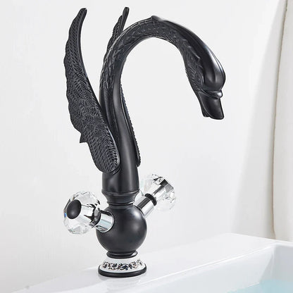 Brass basin faucet deck mounted with black swan design, antique brass finish, crystal knobs, and ornate wing detailing