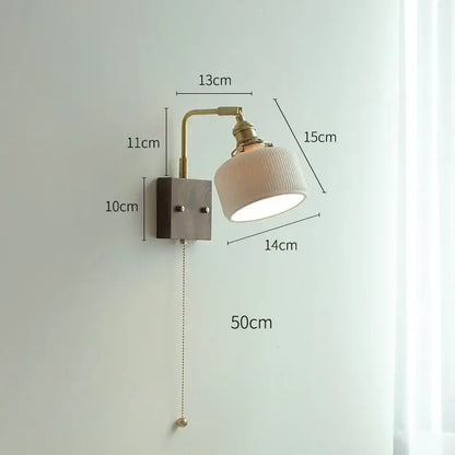 A vintage-style led wall light with brass finish and off-white ceramic shade for living room use