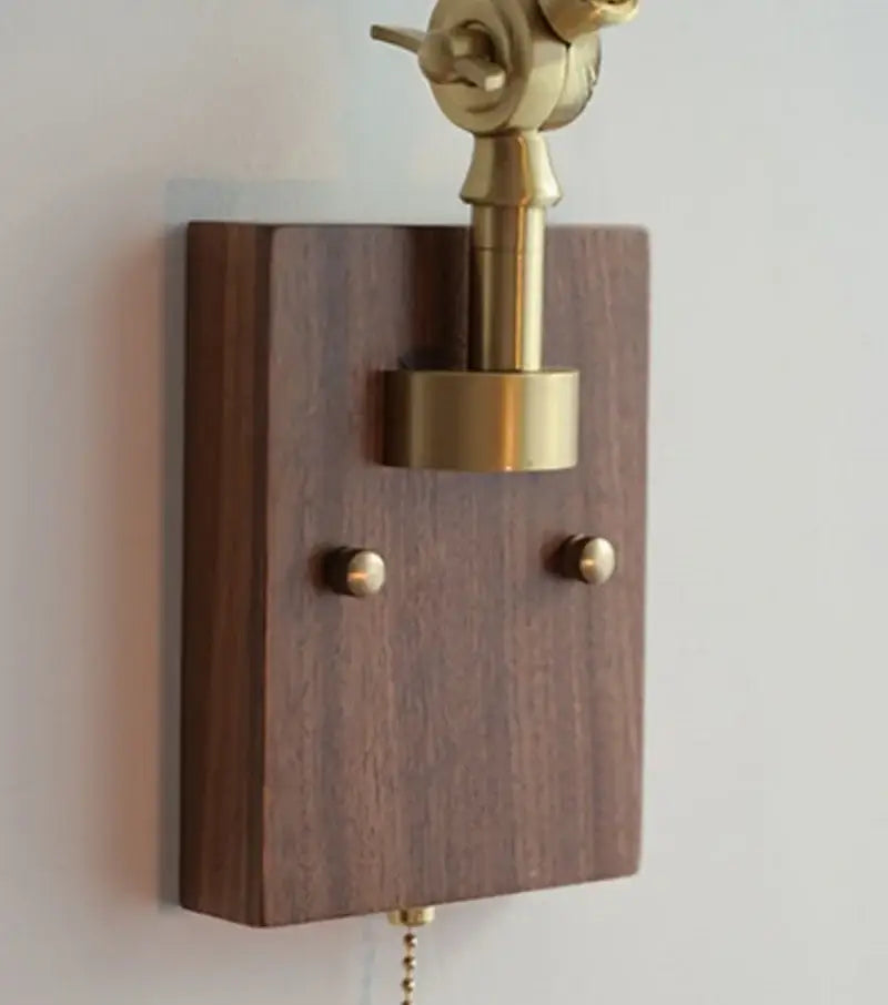 A brass finished adjustable wall lamp with decorbites ash wood base and blue glass for bedroom lighting