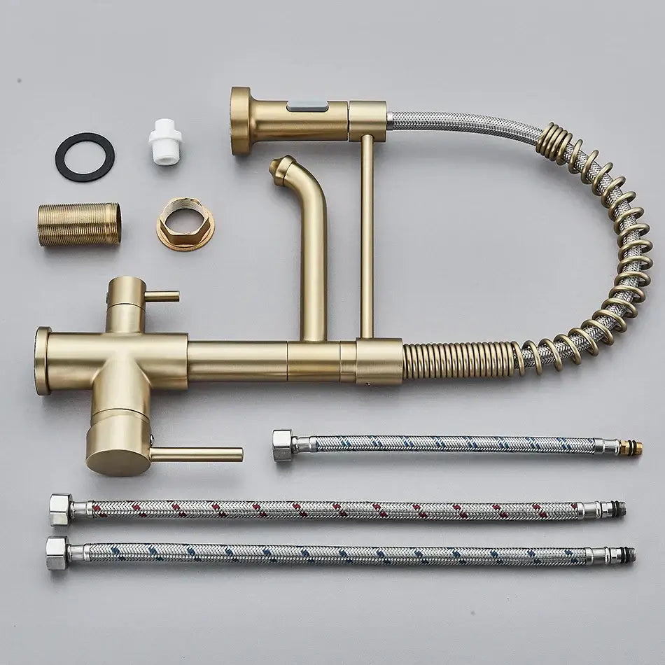 Gold-colored brass dual spout water filter faucet with pull-out spray head and flexible braided hoses for kitchen use