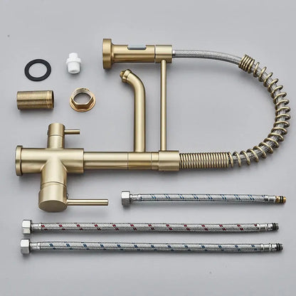 Gold-colored brass dual spout water filter faucet with pull-out spray head and flexible braided hoses for kitchen use