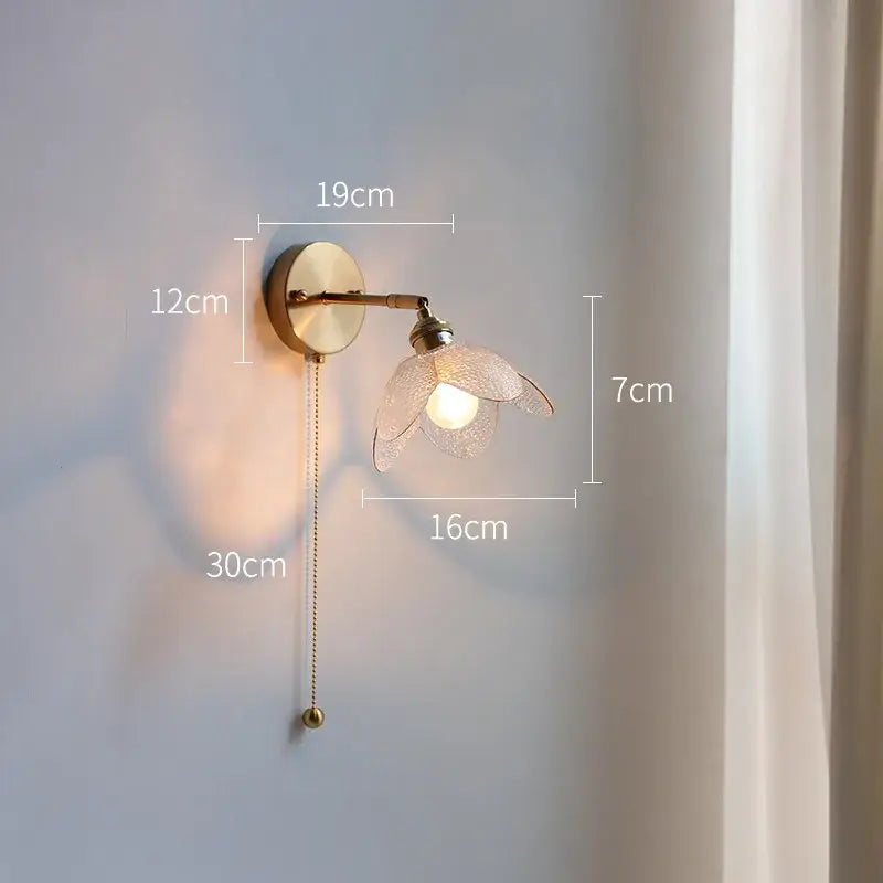 Antique brass-finished wall lamp with gray glass led flower shade and adjustable pull-chain for bathroom use