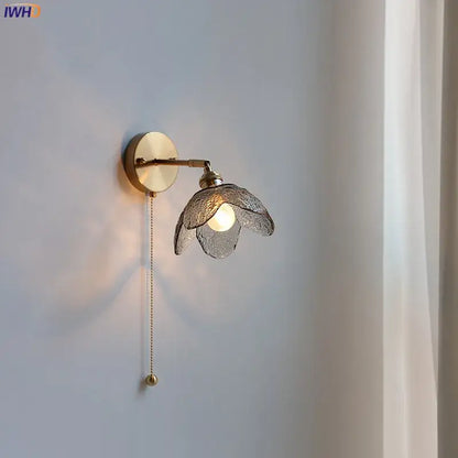 Brass flower gray glass led bathroom wall lamp with textured translucent gray glass shade shaped like open flower