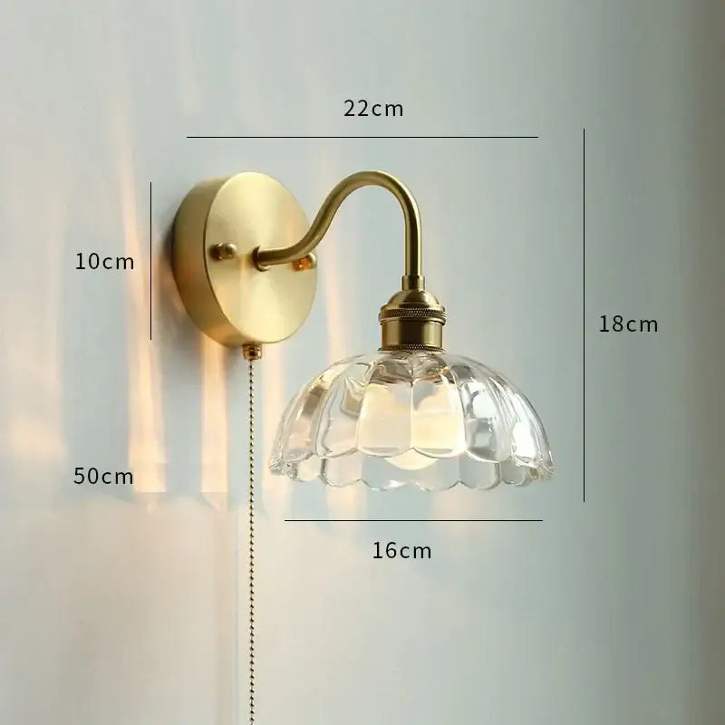 Brass-finished glass copper led wall sconce with clear faceted flower-shaped shade and pull chain for bedroom mirror