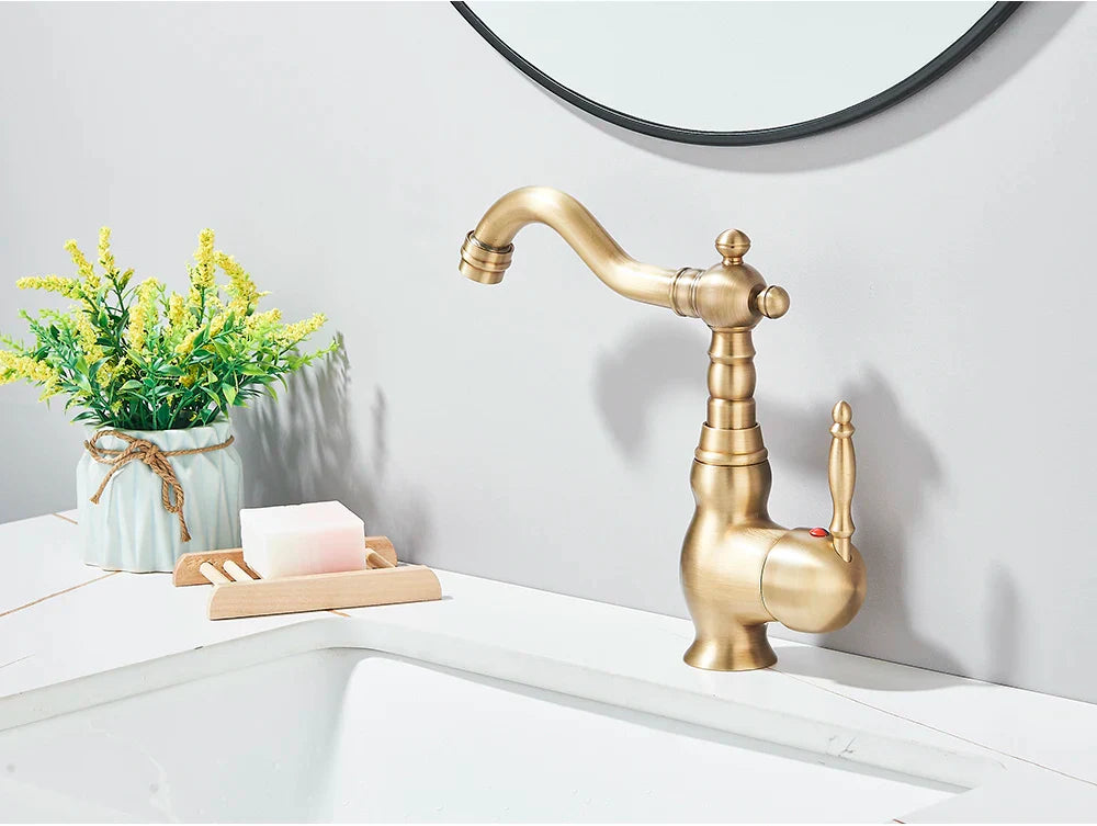 Antique brass-finished deck mounted kitchen faucet with ornate vintage design and rotating curved spout