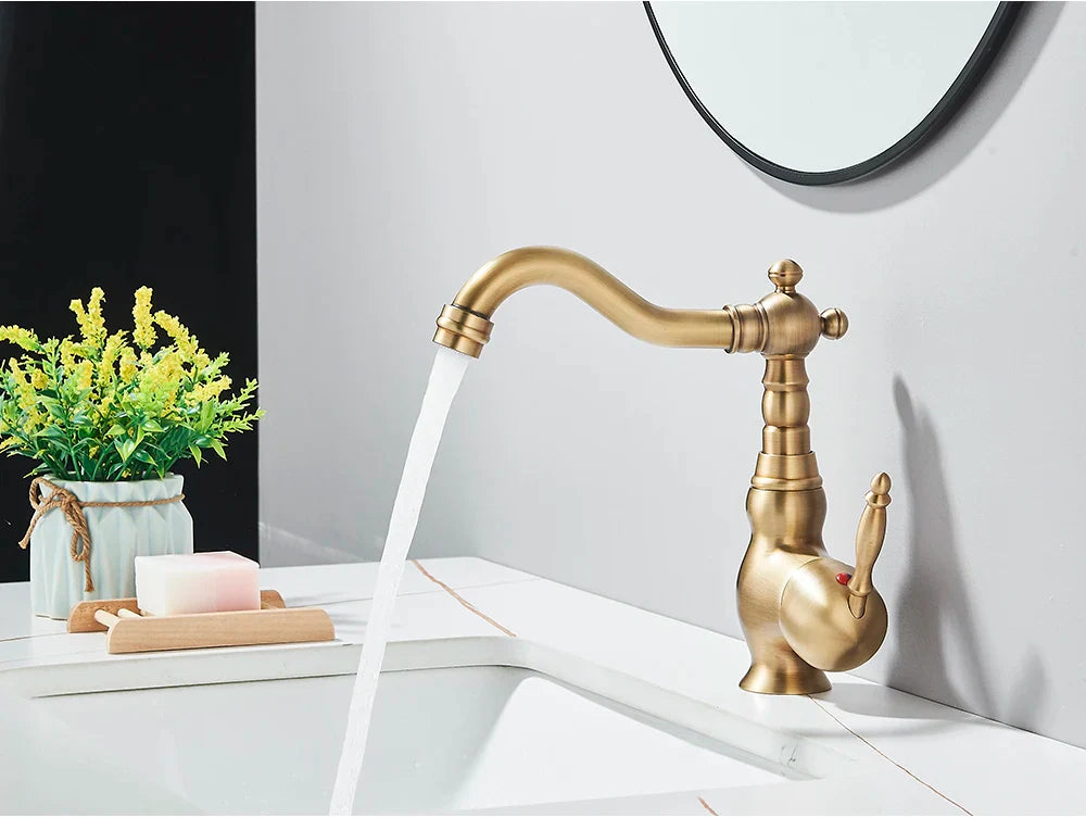 Antique brass-finished deck mounted kitchen faucet with rotating neck and curved spout in vintage ornate design