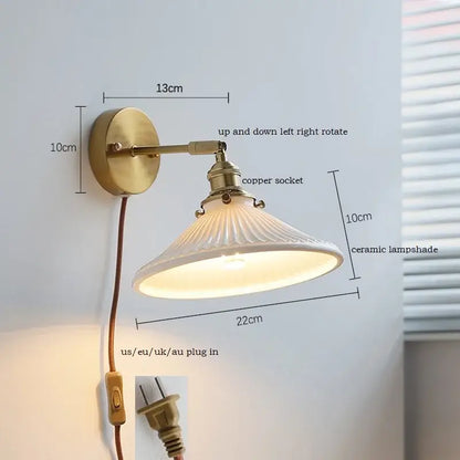 Antique brass wall sconce with iron arm and ribbed white decorbites ceramic shade for bedroom lighting