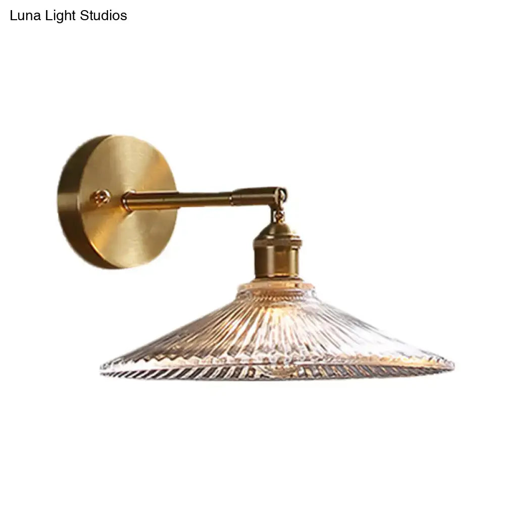 Brass scalloped bedside sconce light fixture with brass finish and clear ribbed glass shade for bedroom use