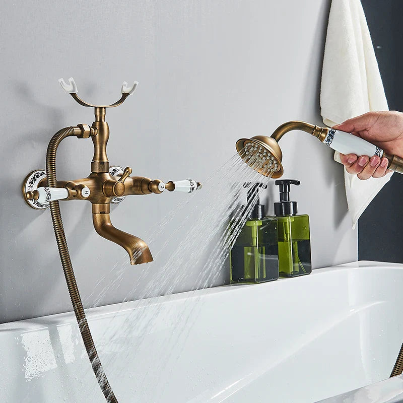 Antique brass shower faucet wall mount with white ceramic handles and handheld showerhead for cold water use