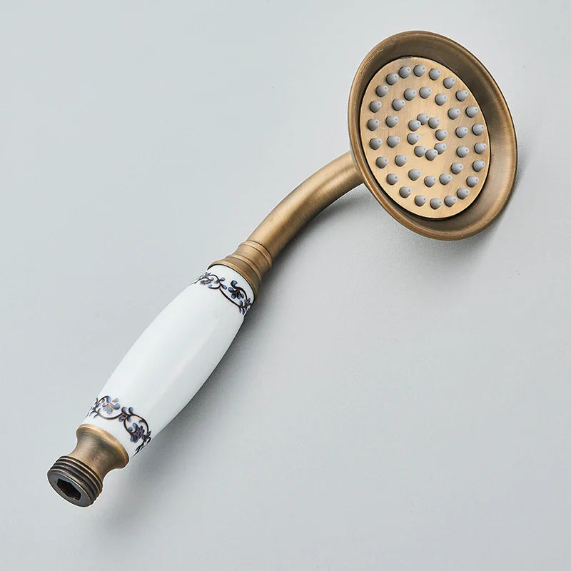 Antique brass-finished wall mount shower faucet with cold water control and white ceramic handle with black floral patterns