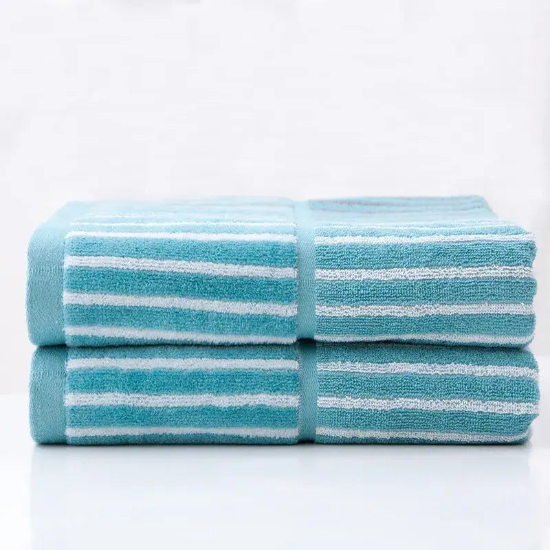 Two neatly folded turquoise and white striped sports fitness towels with a soft textured weave for gym use