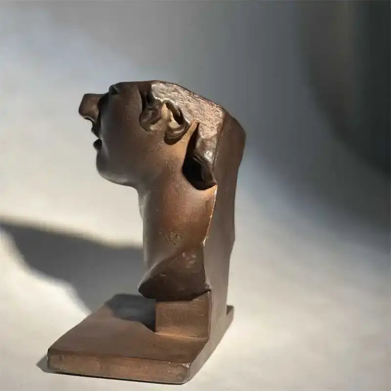 Bronze abstract human face sculpture with stylized features on rectangular base for living room decorbites decor