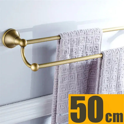 Brass double towel rack with decorative curved connector and light gray towels in decorbites bronze bathroom accessories set