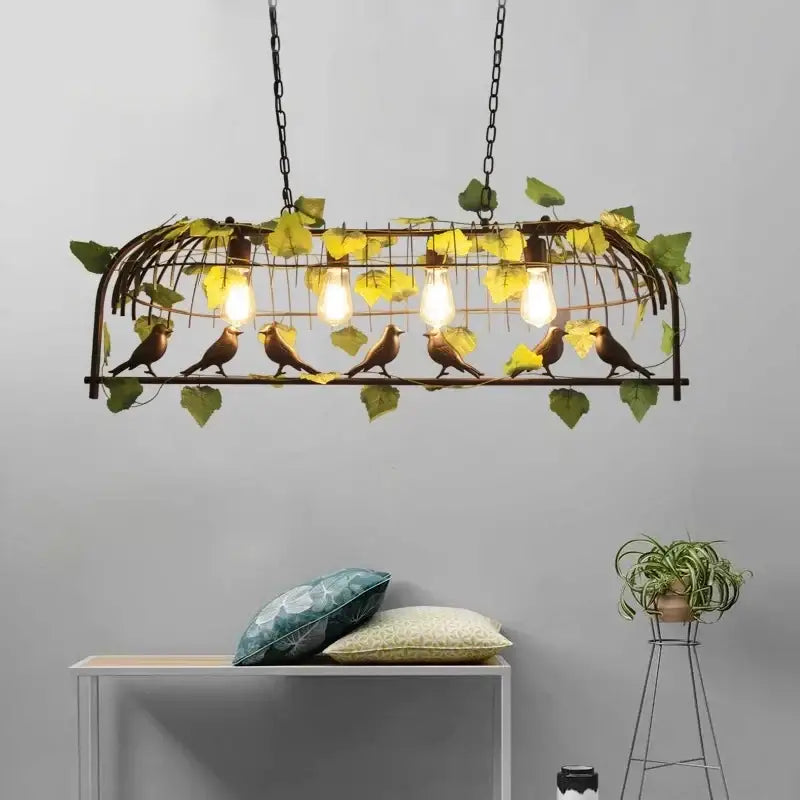 Bronze birdcage pendant lights with wrought iron bird-themed design, golden-brown birds, green leaves, and four bulbs suspended by black chains for dining room decorbites pendant lights