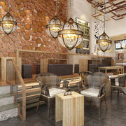 Woven wicker chairs with light gray cushions beneath a decorbites bronze black glass globe chandelier foyer light