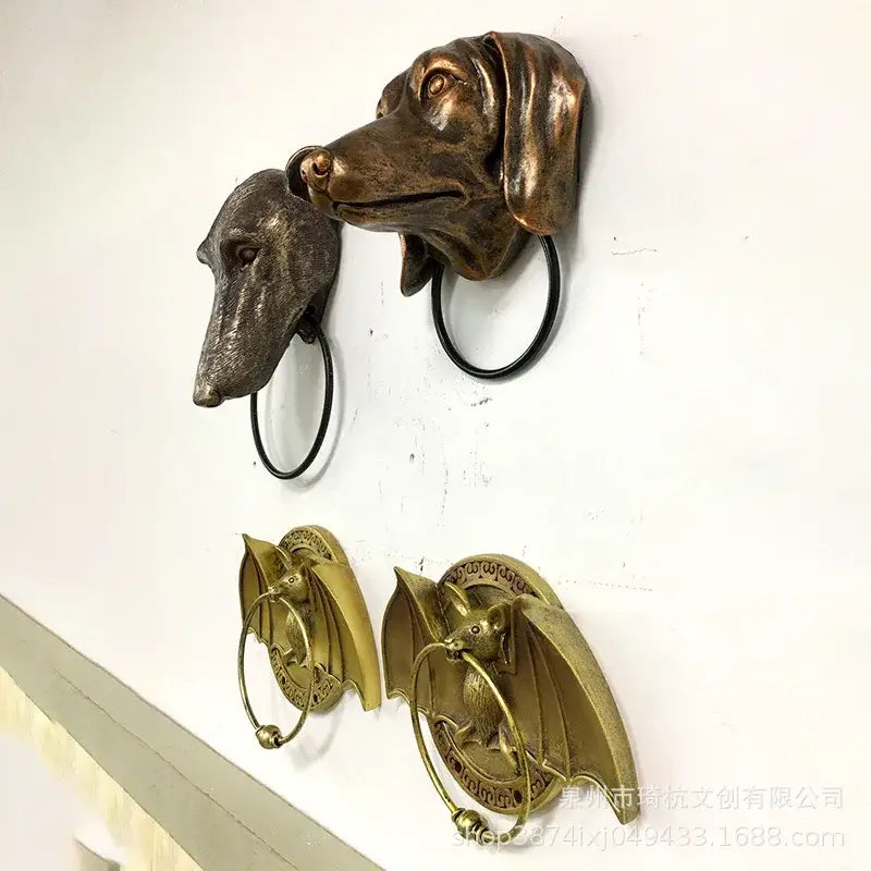 Bronze dog head door knockers with black rings and bat-shaped brass wall decor as courtyard door knocker pendant