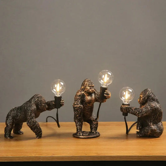 Bronze king kong gorilla table lamp with three bronze-finished gorilla figurines holding lit bulbs for bedroom night light