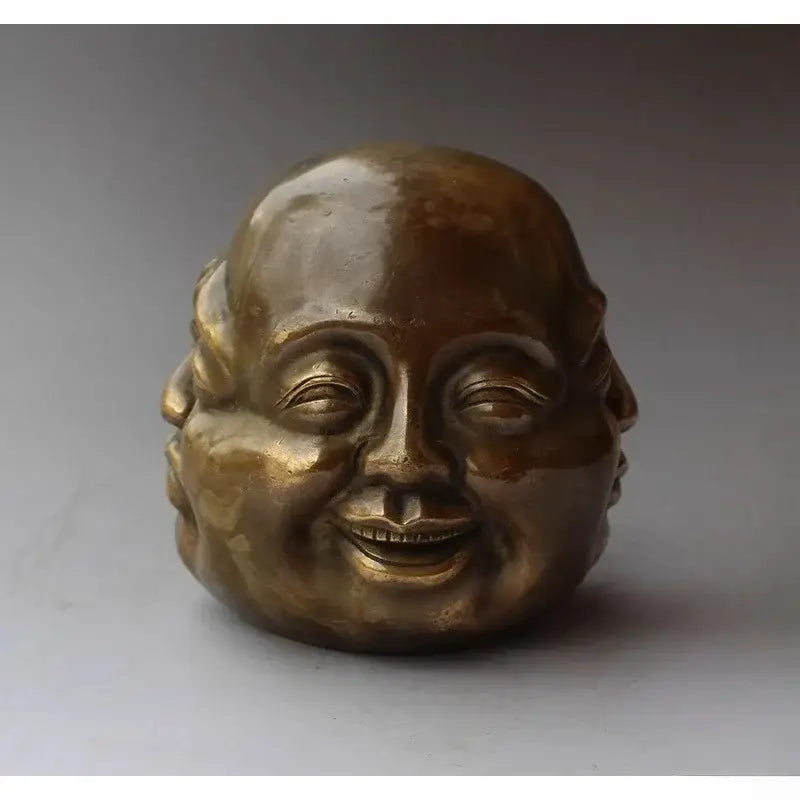 Brass-colored bronze polished buddha head statue with intricate details and serene smiling expression for living room decor