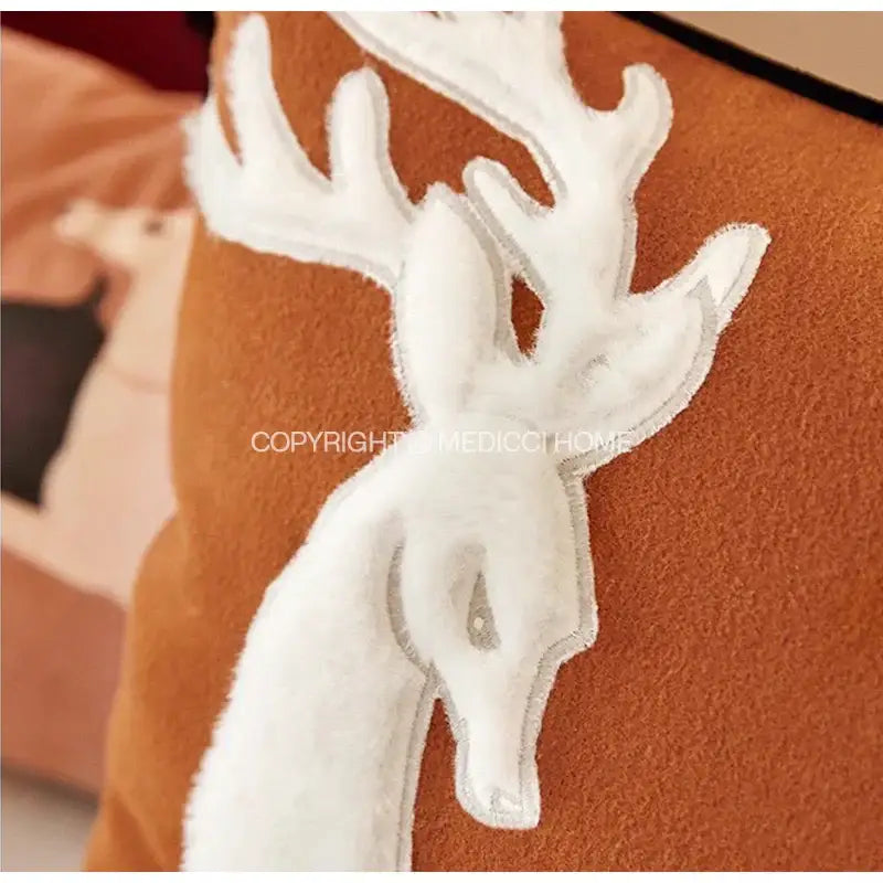 Brown velvet handmade reindeer applique cushion cover with white plush deer appliqué on rust-colored fabric for decorbites