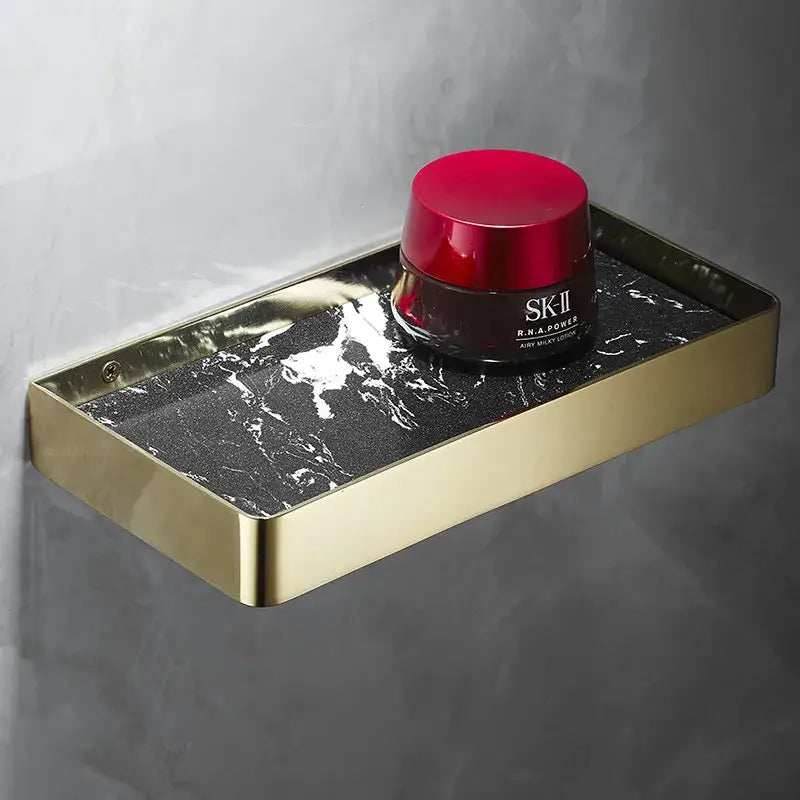 Brushed gold corner shelf with black marble tray holds sk-ii r.n.a. featuring decorbites brushed gold bathroom storage organizer