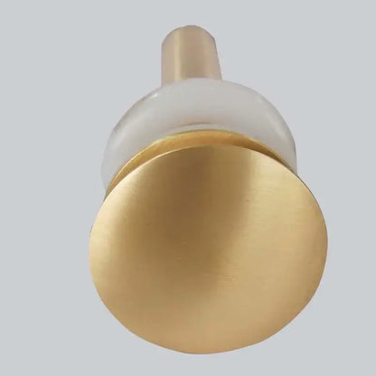 Brushed gold basin sink drain with overflow featuring a gold-toned brass knob and translucent white glass accent by decorbites