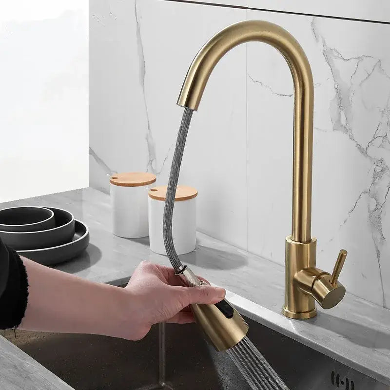 Brushed gold kitchen faucet with pull down spray head featuring a flexible hose and sleek curved spout by decorbites