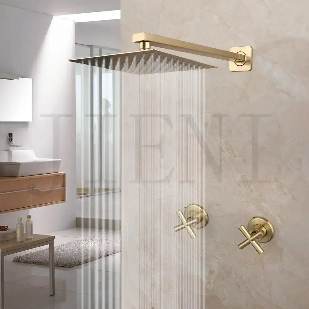 Brushed gold square rainfall shower faucet set with cross-handle faucets mounted on a marble wall